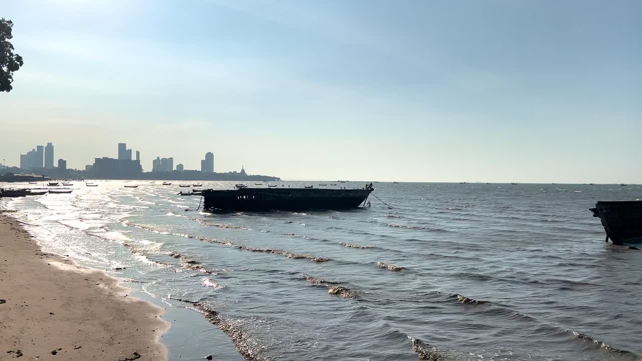 도시 스카이라인과 함께 파타야 해변에 버려진 배