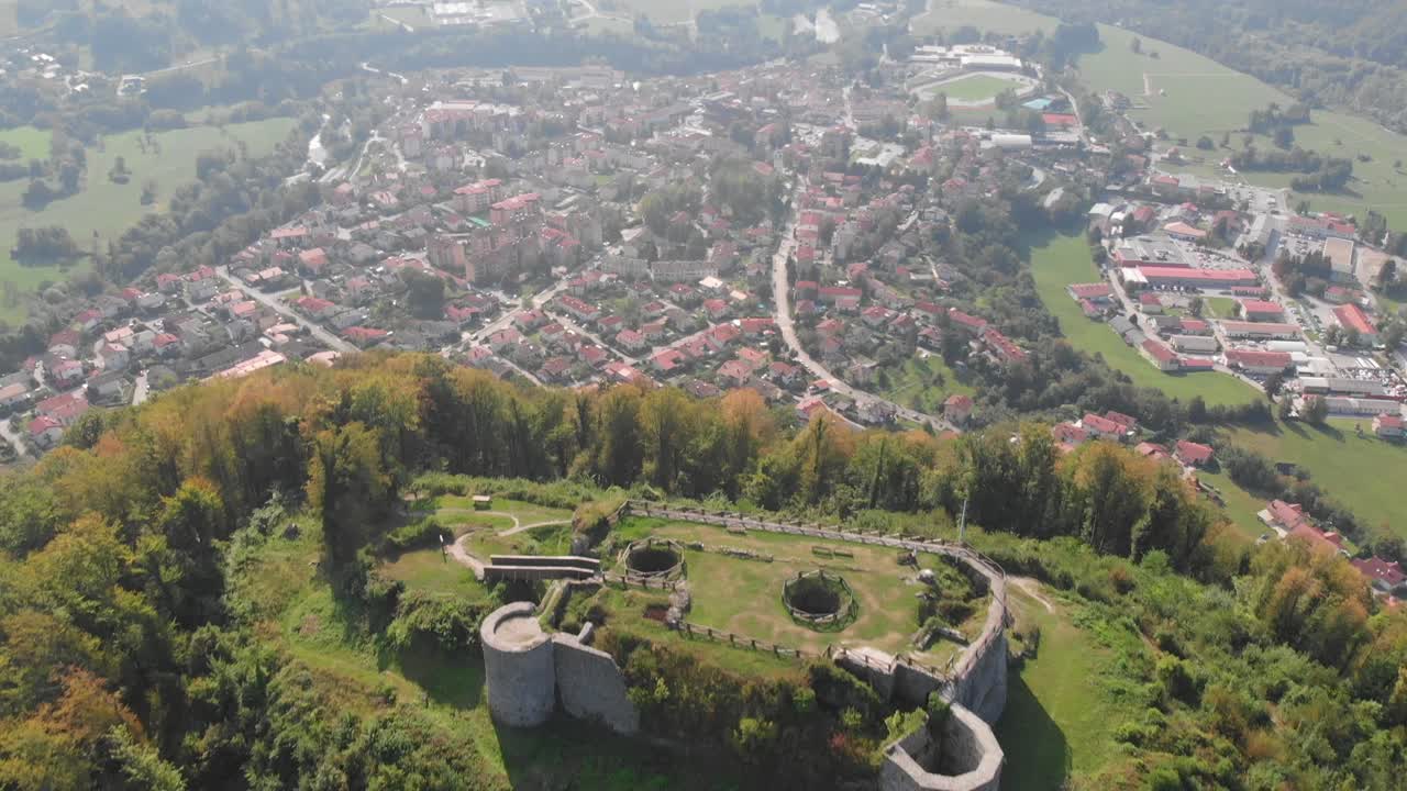 Drone flying above Tolmin in early autumn, revealing historic castle on hill
