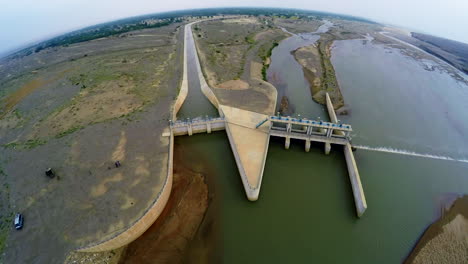 aerial view of spillway of a dam, a van and some visitors are there