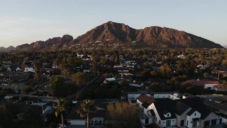 Vista-Aérea-De-La-Montaña-Camelback-Al-Atardecer-Con-Casas-De-Arizona-En-Primer-Plano