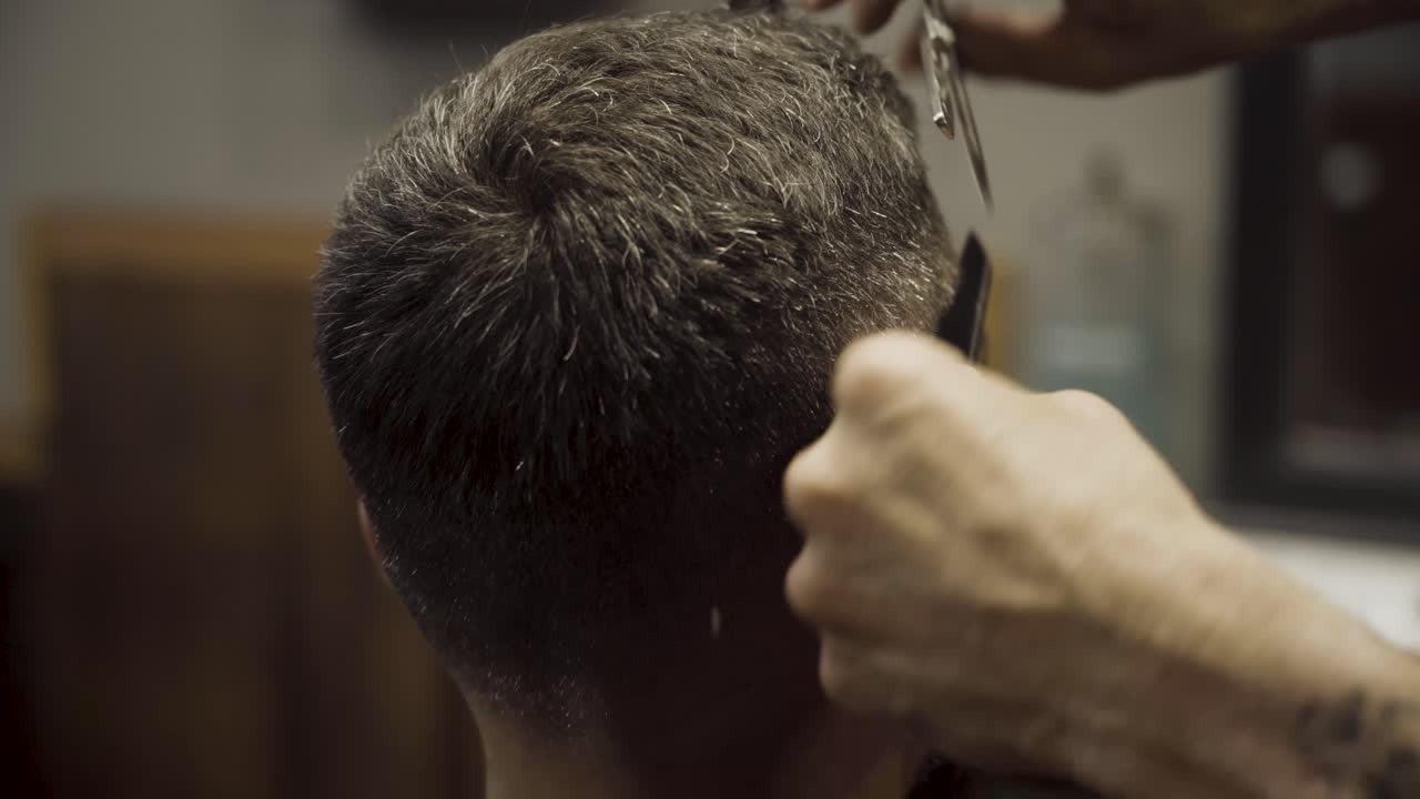 el maestro corta el cabello en la barbería
