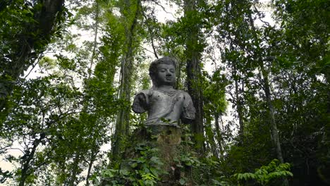 Peaceful-Nature-with-Buddha,-Forgotten-Buddha-Statue-in-the-Jungle,-Buddhism-Ancient-Tradition
