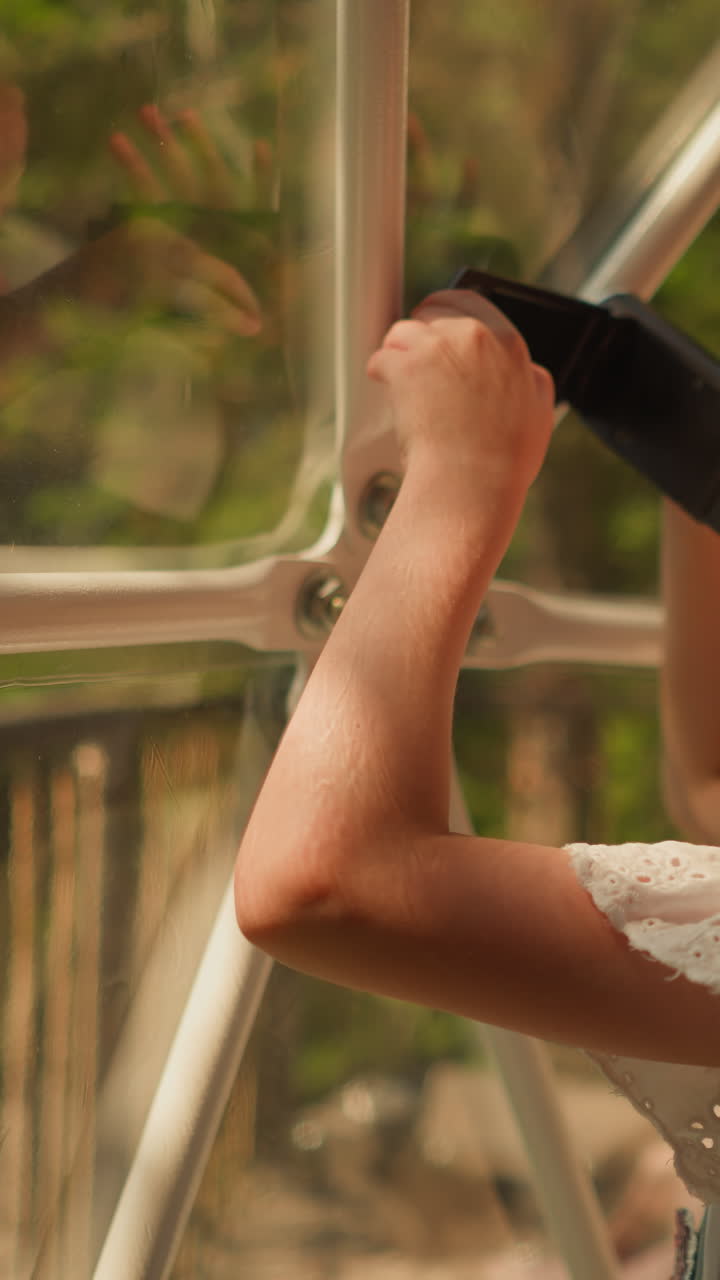 글램핑 텐트에서 디지털 카메라를 고 있는 아이: 작은 소녀가 빛의 날 유리 벽을 통해 풍경의 아름다움을 촬영합니다. 아이는 캠핑장의 사진을 찍습니다.