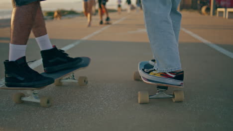 closeup skaters legs riding longboards asphalt road. unknown pair moving speedy