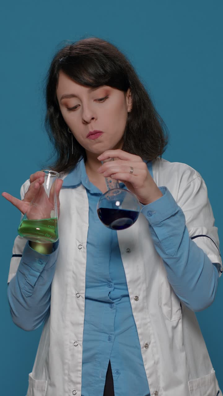 Scientist holding beakers in a lab