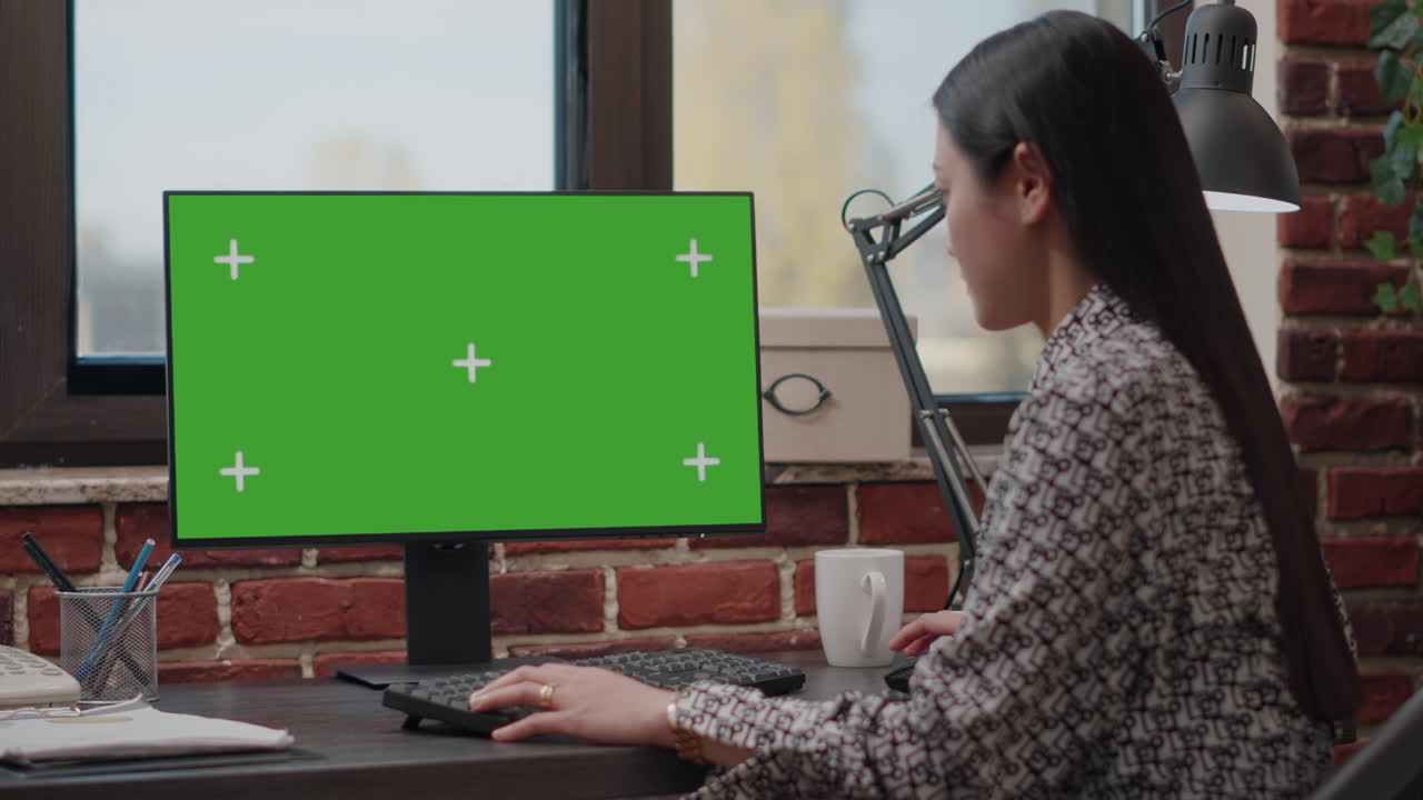 Business woman working with horizontal green screen on monitor