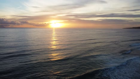 Bright-sunset-over-calm-sea-near-Spain-coastline,-aerial-view