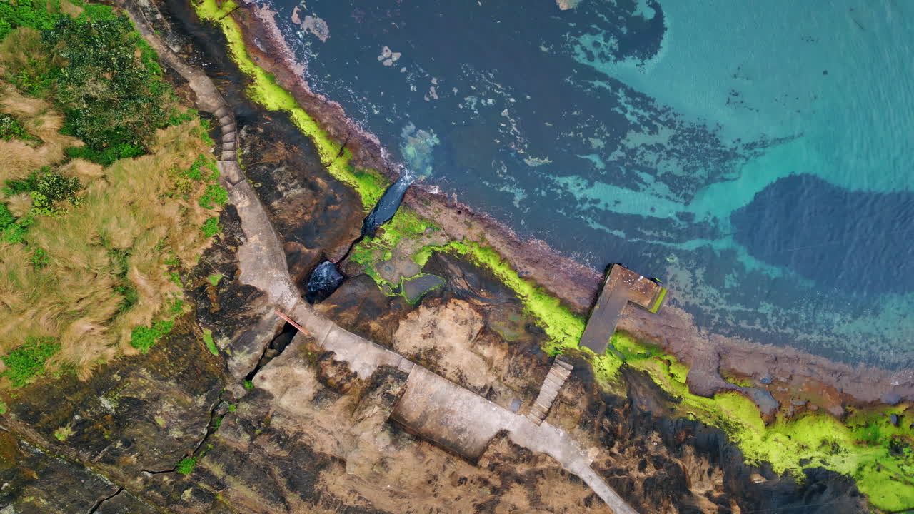 푸르키즈색 물이 해안선을 는 드론. 바다의 파도가 바위 해변에 부히고