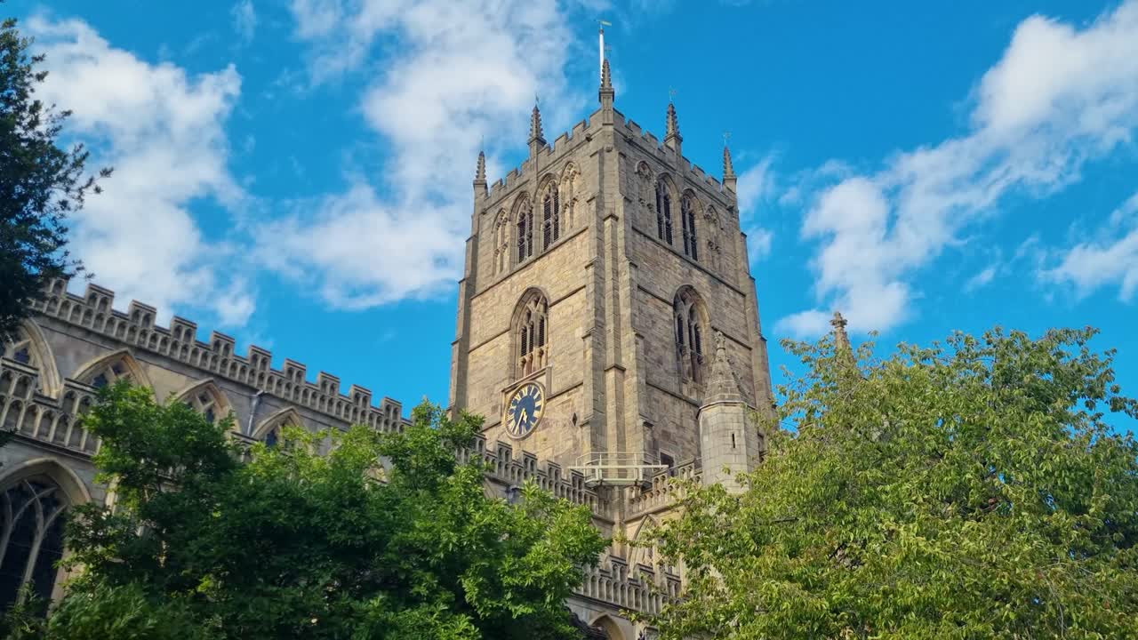 Revealing view of St. Mary’s Church in Nottingham, United Kingdom, showcasing its sunlit bell tower rising gracefully against a clear blue sky