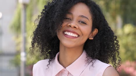 contented black woman smiling in city during daytime