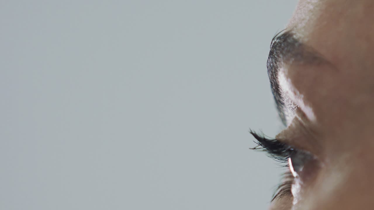 ekstremt nærbillede af kvinde, der påfører eyeliner på øjenbryn, langsom bevægelse