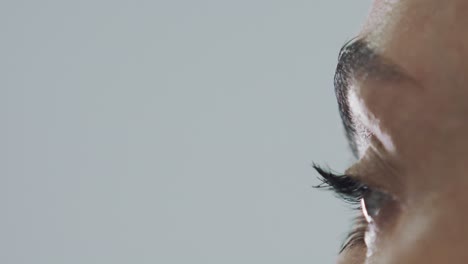 Extreme-closeup-of-woman-applying-eyeliner-to-eyelashes,-slow-motion