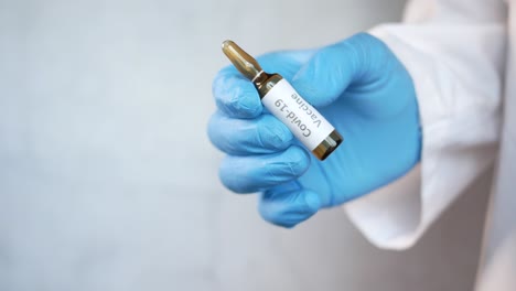 covid-19 vaccine vial held by a healthcare professional