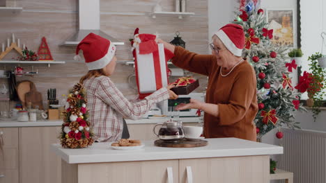 Großmutter-Und-Enkelin-Bringen-Weihnachtsgeschenkpapier-Mit-Schleife-Darauf