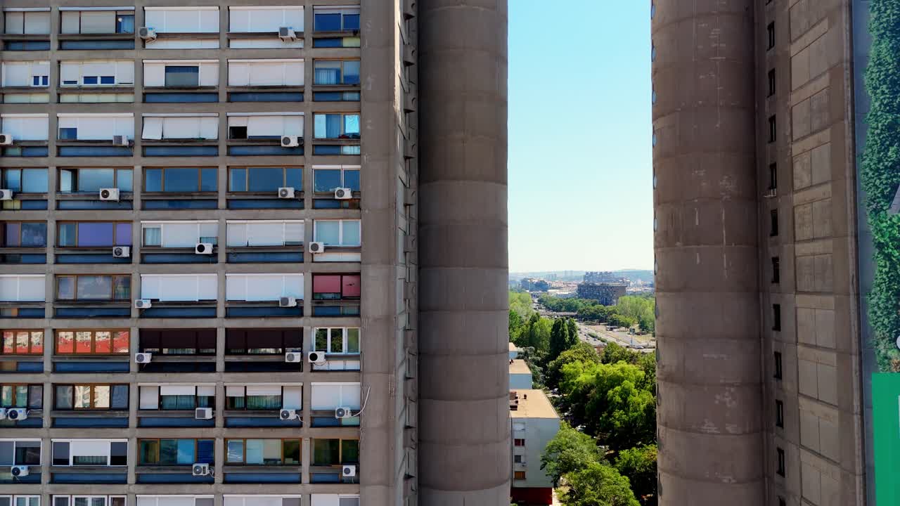 Aerial drone close-up of Genex Tower in Belgrade, Serbia iconic brutalist skyscraper of Yugoslav modernism, showing the narrow passage between twin concrete towers