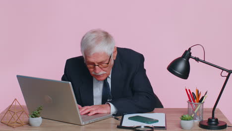 worried senior businessman sits at workplace avoid working and playing racing or shooter video games