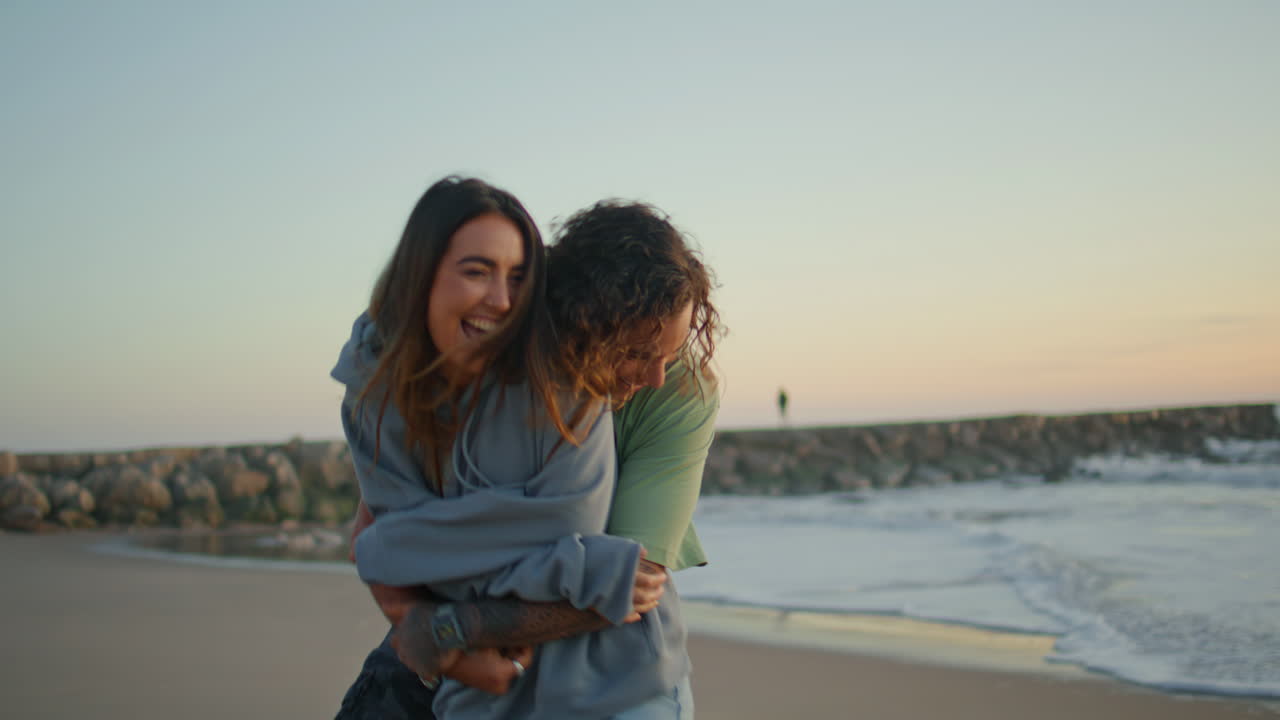 Carefree lovers having fun at sunset beach. Love couple embracing at sea coast