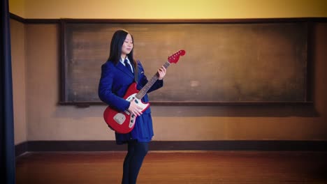 japanese girl in uniform poses with electric guitar in school scene