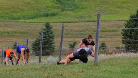 Front-view-of-fit-Mixed-race-people-crawling-through-barbed-wire-fence-4k