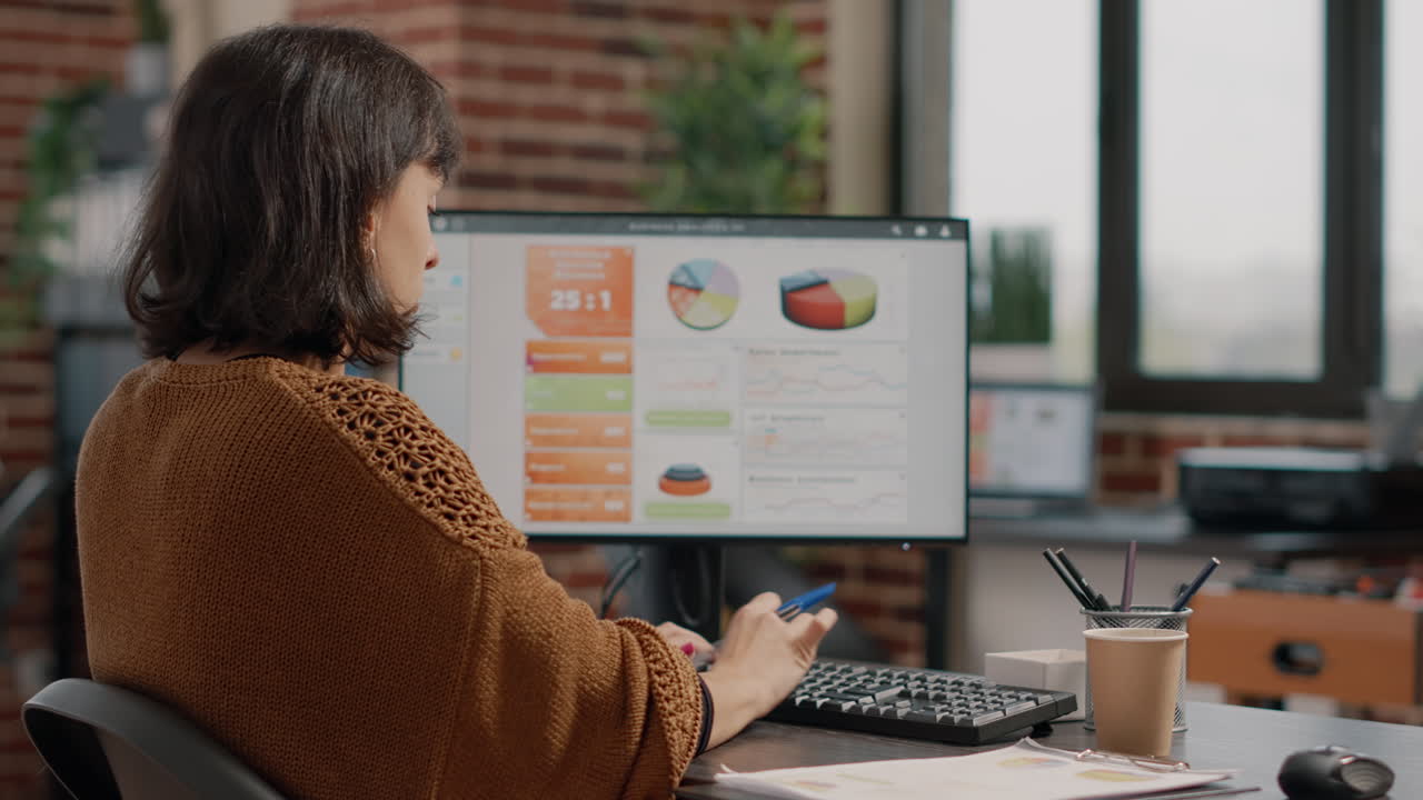 Woman Analyzing Data on Computer in Office