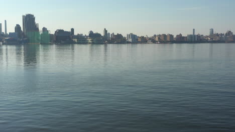 A-low-angle-drone-shot-over-a-calm-Hudson-River-at-sunrise