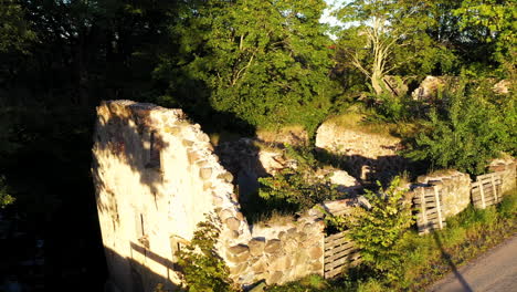 Water-mill-ruins-from-20th-century-in-Blome,-Latvia,-aerial-backwards