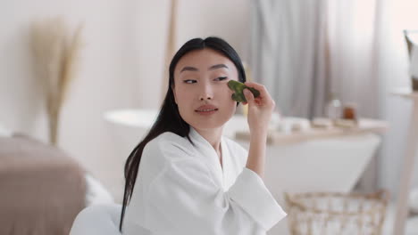 woman using jade roller for facial massage