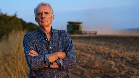 farmer reflecting on sunset over fields. a farmer stands proudly with arms crossed as the sun sets over harvested fields, exuding dedication and resilience