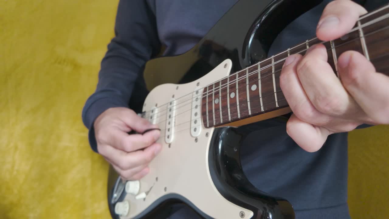 Capturing the intensity of hands skillfully playing an electric guitar with a pick during an engaging recording session