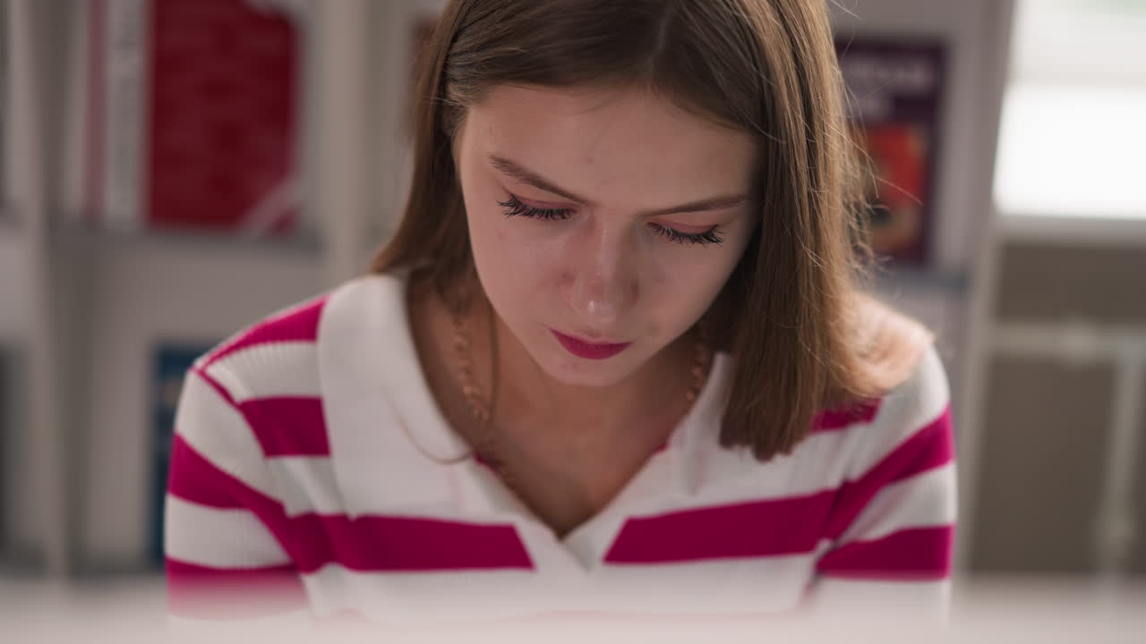 mujer trabaja en la mesa en la biblioteca de la universidad de cerca. señora seria lee publicaciones y libros en el escritorio en la sala de almacenamiento de literatura. estudiante aprende la lección