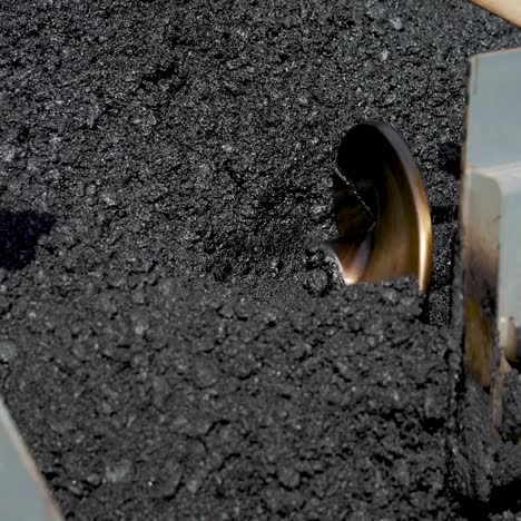 professional equipment with a mixer is blending a mix of rubble, tar, sand and bitumen for stowage asphalt on the highway. manufacturing technology of asphalt concrete sweep for road works