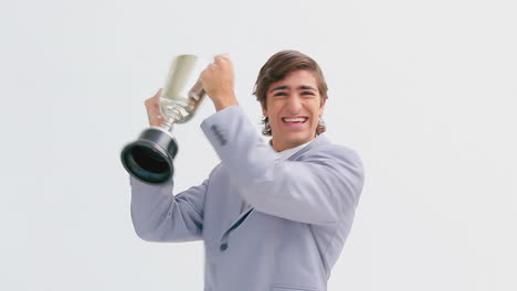 hombre sonriente sosteniendo un trofeo