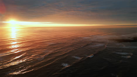 establishing aerial drone shot over sea at stunning sunrise in north yorkshire at low tide uk