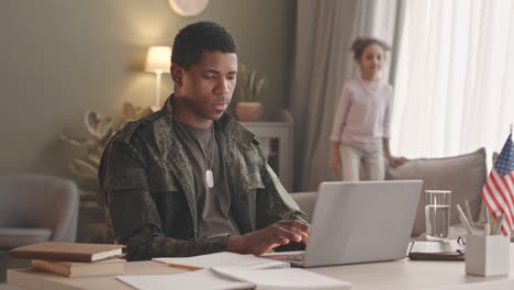 african american soldier working on laptop from home