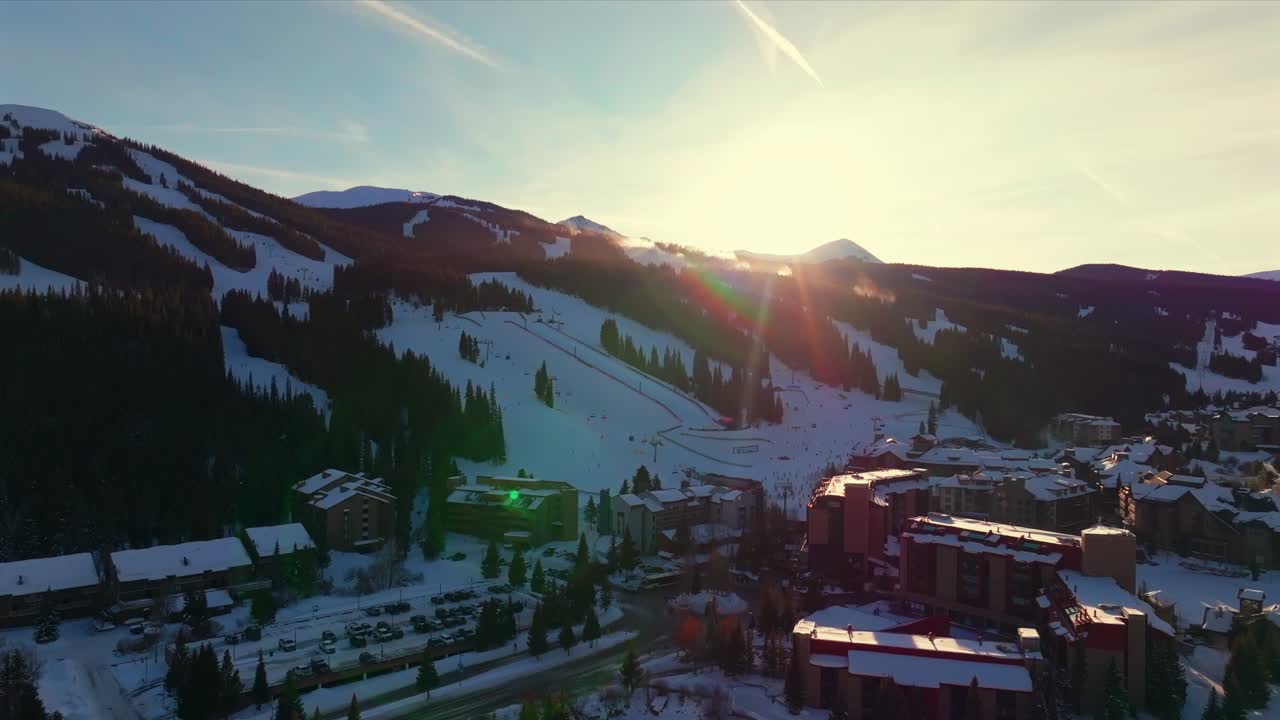 Copper Mountain Ski Resort Center Village Winter Solstice December sun flares sunset aerial drone Colorado fresh snow American Flyer Eagle lodge hotel chairlift gondola snowboarders trails upwards