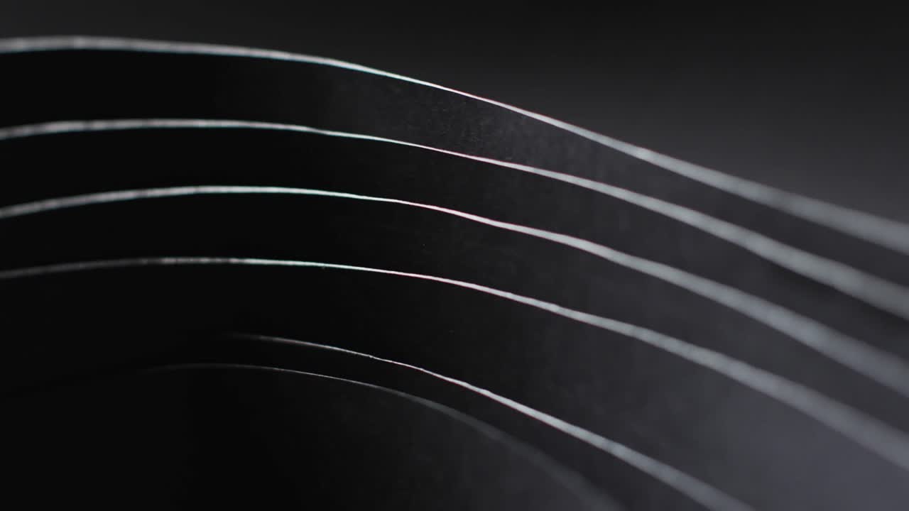 검은색 바탕에 있는 검은색 종이 층과 복사 공간의 클로즈업 비디오