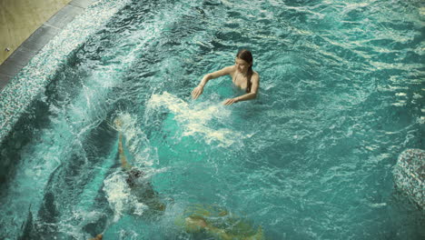 vista superior de una pareja feliz divirtiéndose en la piscina. una pareja sonriente chapoteando en la piscina