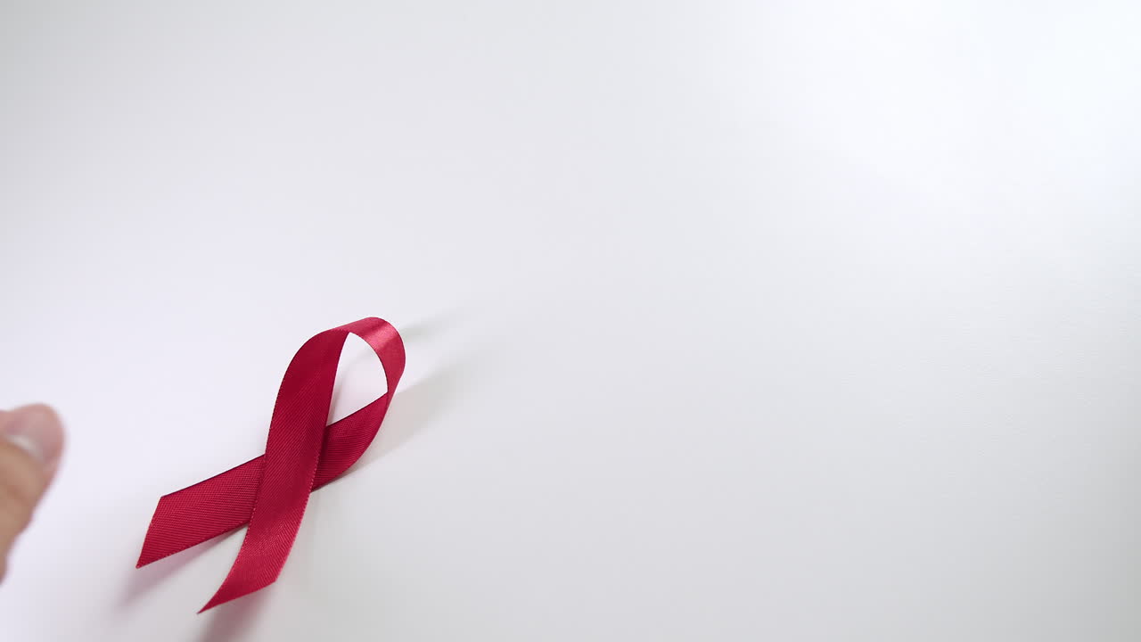 Placing a red ribbon on the left side of the frame which signifies the HIV-AIDS worldwide disease awareness and prevention.