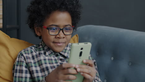 child using smartphone on couch