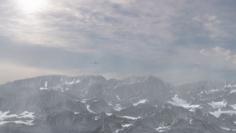 airplane flying over snowy mountains