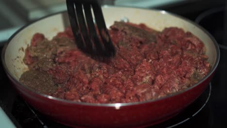 raw and cooked ground beef in red pan