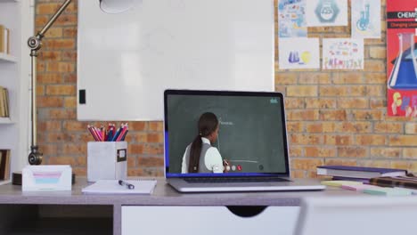 Mixed-race-female-teacher-displayed-on-laptop-screen-during-video-call