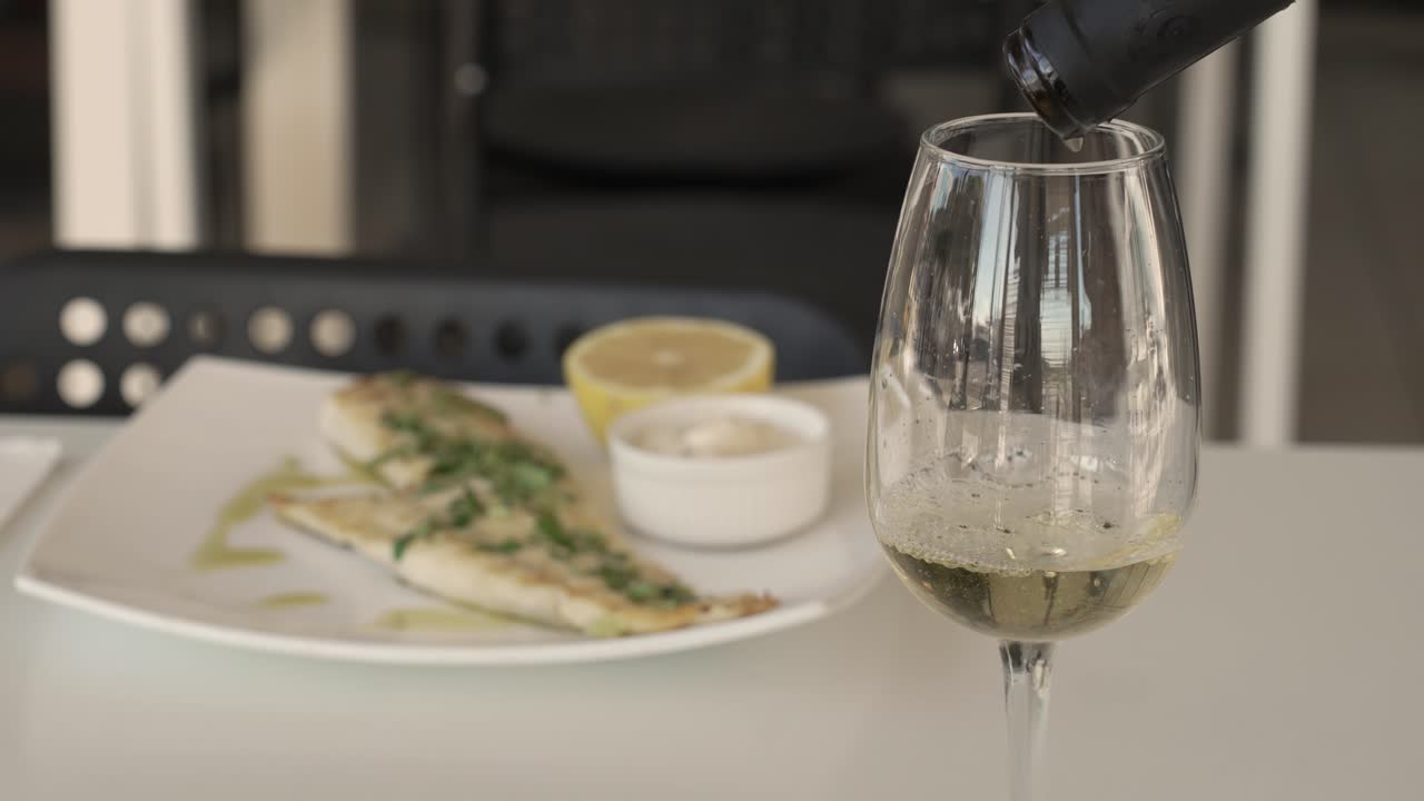 Delightful dining experience featuring fresh fish and refreshing white wine at a vibrant seaside restaurant