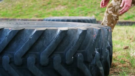 military man lifting a big tire at boot camp