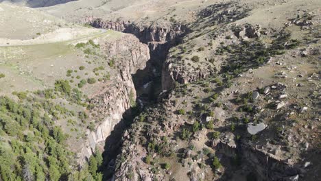 Vista-Aérea-Inclinada-De-Shell-Creek-Y-Sus-Altas-Paredes-De-Cañón-A-Lo-Largo-De-La-Ruta-14-En-Wyoming-En-Un-Día-De-Verano