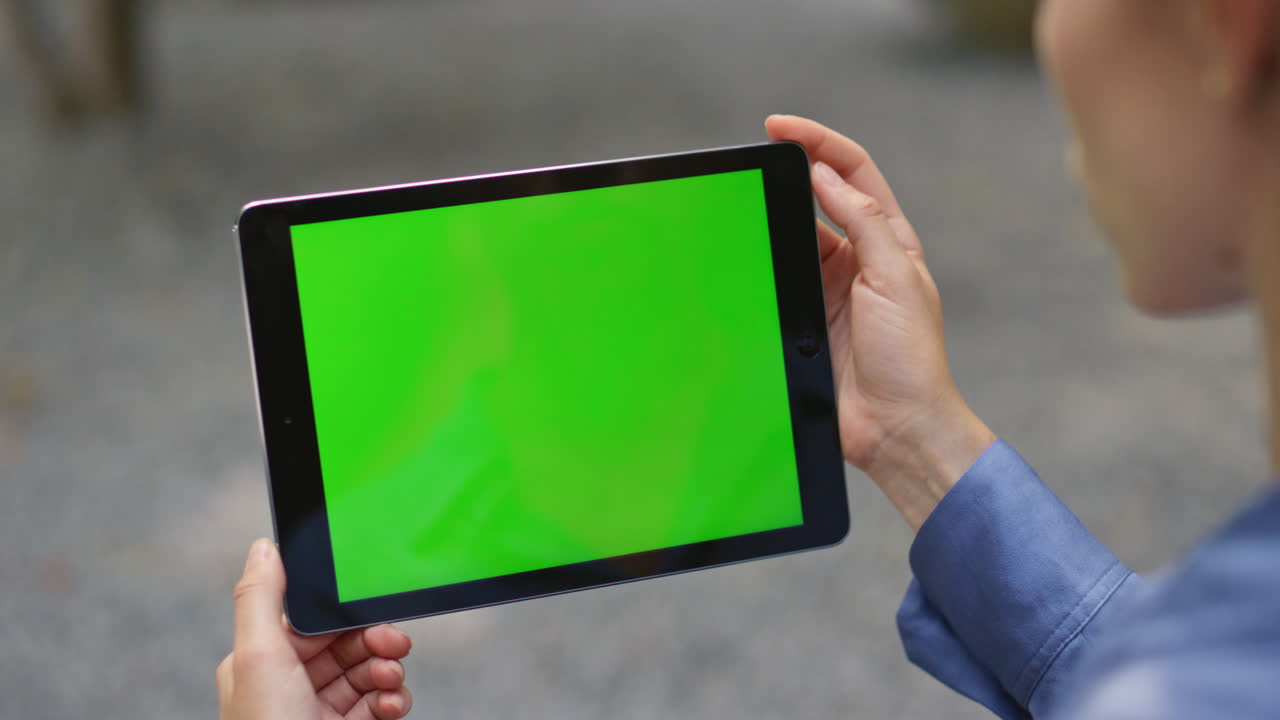 manos sosteniendo el pad verde en un primer plano de fondo borroso. mujer viendo la llave de croma