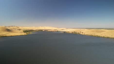 aerial view of a calm lake surrounded by dry hills