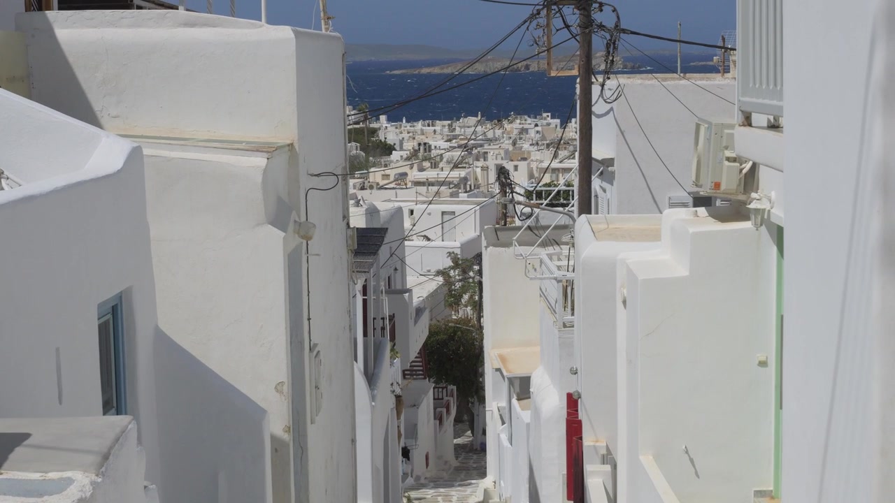 Stretto vicolo imbiancato a calce e sentiero acciottolato tra case cicladiche a Mykonos, Grecia