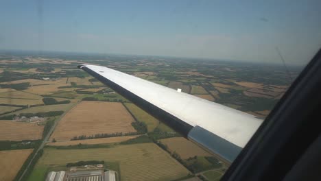 look out the window of a small private jet flying over fields