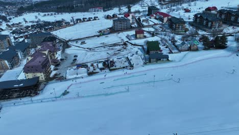 A-picturesque-winter-village-nestled-in-the-snow-covered-mountains,-with-charming-houses-and-trees-dusted-with-snow,-creating-a-cozy-and-festive-atmosphere